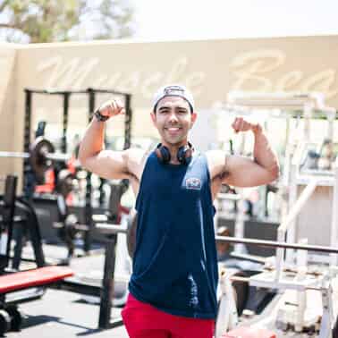 A man flexes his biceps at a gym